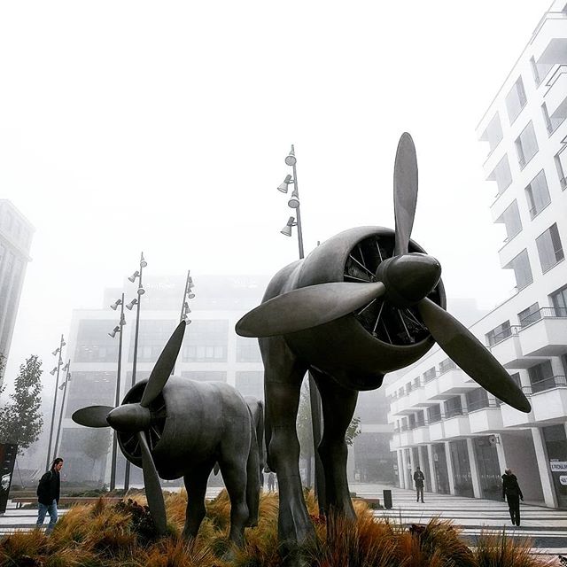Surreal sculptures of turbines with large bovine legs.